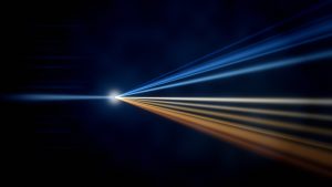 Abstrakte Lichtgrafik: ein gebündelter Lichtstrahl fächert an einem Brennpunkt in ein Spektrum von kühlem Blau bis warmem Gold auf